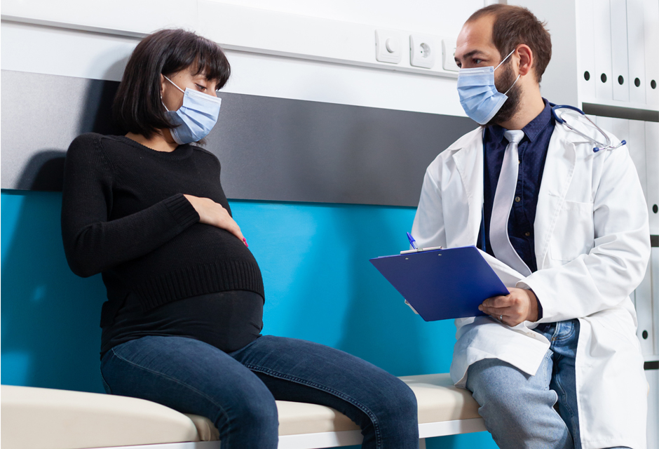 Mulher gravida conversando com medico